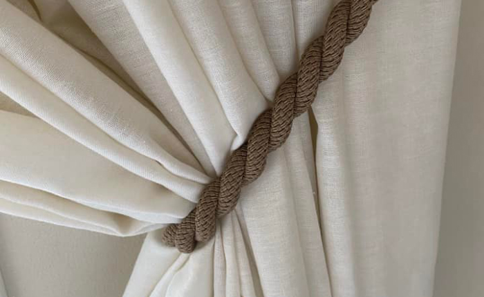 una tenda in misto lino sorretta da una corda marrone